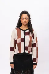Saco tipo cardigan de punto con diseño geométrico de bloques en tonos beige, marrón y bordó. Presenta cuello redondo, cierre frontal con botones negros y mangas largas con puños en contraste.