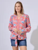 Blusa estampada con cuello a la base, escote en V y aplique de puntilla. Terminación de ruedo con nudo.