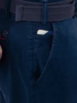 Pantalón chino de hombre color azul marino, de corte slim fit, confeccionado en gabardina de algodón, con bolsillos laterales y traseros, y cierre frontal de cremallera y botón.