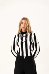 Polera de tejido de punto con diseño de rayas verticales anchas en blanco y negro, cuello alto y manga larga.