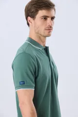 Remera polo de piqué azul marino, con cuello y puños de mangas cortas con ribete blanco en contraste, cierre frontal de dos botones y pequeño logo bordado en el pecho.