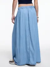 Falda larga negra de denim liviano en 100% lyocell, de silueta amplia y fluida, con cintura con elástico en la parte trasera, bolsillos laterales y recorte delantero con costuras a contratono.