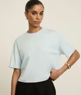 Remera boxy de algodón peruano color celeste, con cuello redondo y mangas cortas amplias.