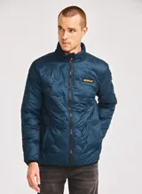 Chaqueta acolchada de peso medio en color azul petróleo, con cierre frontal de cremallera, cuello alto y parche de silicona con el logotipo de la marca en el pecho. Cuenta con bolsillos laterales y ribetes elásticos en puños y dobladillo.