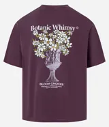 Remera boxy de algodón desteñido color lila, de corte holgado, cuello redondo y manga corta. Cuenta con un pequeño estampado floral en el pecho y un diseño más grande en la espalda.