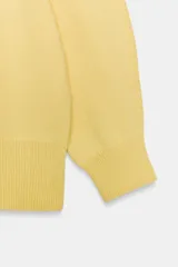 Jersey de punto color amarillo claro, con cuello redondo y mangas abullonadas.