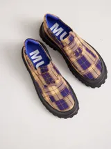 Mocasines con plataforma de goma negra, confeccionados en lona con estampa a cuadros en tonos violeta, amarillo y beige, y detalle de elásticos laterales ocultos.