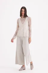 Pantalon tipo palazzo de corte amplio y tiro alto, confeccionado en tejido plisado con acabado brillante.