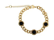 Pulsera de acero con baño dorado, compuesta por una cadena de eslabones y tres dijes circulares con detalles en negro y números romanos.