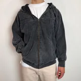 Campera con capucha y cierre frontal, confeccionada en tela con efecto lavado desgastado. Presenta costuras decorativas horizontales en el pecho y bolsillos laterales.