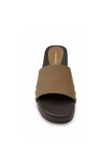 Zuecos de mujer marca Paddock modelo Lua, de color marrón, con suela tipo madera, tira ancha en el empeine y detalle de tachas metálicas doradas en el lateral.