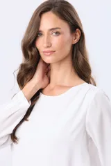 Blusa clásica de manga larga en color blanco, con cuello redondo y diseño fluido.