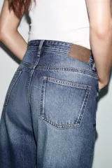 Jeans de tiro bajo con diseño de cinco bolsillos, corte recto y cierre frontal con cremallera y botón.