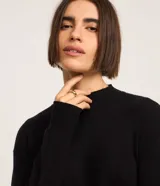 Suéter de punto bordó, con cuello alto, mangas largas y costuras verticales decorativas en el frente.