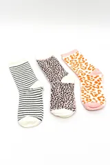Pack de tres pares de medias estilo crew con diseños variados: un par a rayas horizontales blancas y negras, un par con estampado animal print en tonos rosado y negro, y un par con estampado animal print en tonos blanco y naranja.