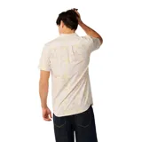 Camisa de manga corta Rip Curl modelo Vaporcool Sessions Aerotech, color blanco con estampado tropical de palmeras en tonos amarillos y rosados. Cuenta con cuello camisero, cierre frontal de botones y un bolsillo aplicado en el pecho con etiqueta de la marca.