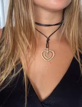 Gargantilla tipo choker de gamuza negra con dije de corazón dorado.