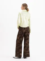Pantalón de corderoy de algodón con silueta wide leg y tiro alto. Presenta un diseño de estampado camuflado con detalles de corazones bordados distribuidos en la prenda.