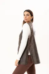 Chaleco de cuero marrón con silueta relajada, caracterizado por detalles de ojalillos metálicos a lo largo de los bordes frontales.