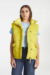 Chaleco puffer amarillo con cuello alto, cierre frontal con cremallera y broches a presión, y bolsillos delanteros con solapa.