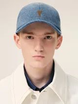 Gorra de jean celeste con logo bordado en marrón.