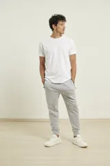 Pantalón de jogging color verde militar, corte slim, con puños elastizados en los tobillos y cordón ajustable en la cintura. Presenta un bolsillo lateral con cierre.