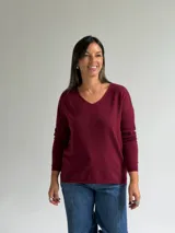 Sweater de punto en color bordó, con escote en V, mangas largas y diseño de corte recto con dobladillo ligeramente más largo en la parte posterior.