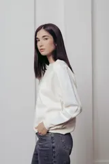 Sweater color crema de punto con cuello redondo y mangas largas con paneles de lentejuelas plateadas.