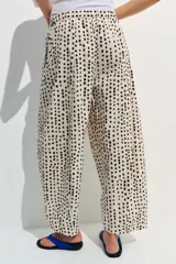 Pantalón estilo pijama de tiro medio, confeccionado 100% en algodón. Cuenta con cintura elástica, bolsillos laterales ocultos en la costura y diseño de corte barrel con estampado de lunares.