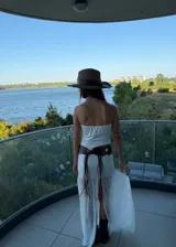 Vestido largo negro con diseño strapless, cuerpo ajustado y falda con capa superior transparente que aporta movimiento y ligereza.