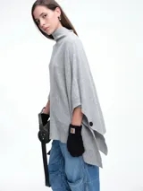 Poncho amplio de cuello alto, confeccionado en hilado con lana y cashmere, con diseño de caída recta y botones laterales.