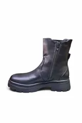 Bota de caña media color negro, estilo chelsea, con paneles elásticos laterales y suela track dentada.