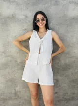 Chaleco tejido color beige con lurex, escote en V y lazos para atar en el frente.