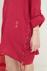 Camisa de algodón blanca, de manga larga y corte oversize, con diseño abierto en los laterales ajustable mediante cordón y ojalillos.