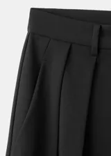 Pantalón de vestir negro de tiro medio con diseño wide leg, detalle de pinzas frontales, bolsillos laterales y cierre delantero con botón, gancho y cremallera ocultos.