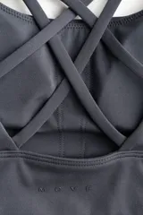 Top deportivo H&M con SoftMove™ Medium Support, color gris oscuro, con escote redondo y tirantes finos dobles cruzados en la espalda.