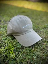 Gorra de gabardina color verde oliva con visera curva y logo 'Nativo' bordado en blanco en el frente.
