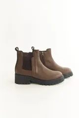 Botas Chelsea negras de cuero con elástico lateral, suela track y tirador trasero.