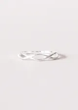Anillo minimalista con diseño de símbolo de infinito entrelazado, acabado en color plata.