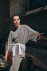 Jersey de punto gris jaspeado, de corte oversize, con cuello redondo y mangas cortas amplias.