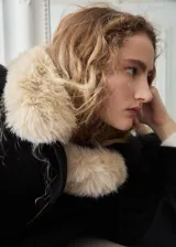 Chaqueta corta de paño color negro con cuello amplio, solapas anchas y detalle de cuello desmontable de piel sintética en tono beige. Cuenta con cierre frontal de botones y mangas holgadas.