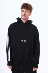 Buzo tipo canguro de felpa color negro, con capucha, bolsillo frontal tipo canguro, estampa frontal con texto y detalle de tres líneas blancas en las mangas.