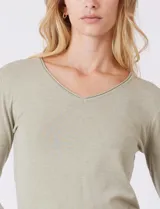 Buzo de tejido fino con escote en V y mangas tres cuartos. Presenta un diseño liso y entallado, ideal para un look casual y versátil.