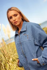 Campera de jean con mangas de denim azul y espalda confeccionada en tejido con diseño geométrico multicolor.