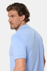 Remera polo lisa de piqué en color celeste, con cuello camisero, cierre frontal con botones y manga corta.