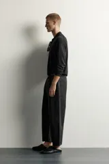 Jeans tapered wide fit de hombre, confeccionados en denim de algodón con efecto lavado en tono azul oscuro. Presentan diseño de cinco bolsillos, tiro medio, corte relajado y cierre frontal con cremallera y botón.