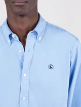 Camisa celeste de algodón con cuello abotonado, corte regular fit, manga larga con puños simples y logo bordado en el pecho.