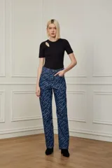 Pantalón de jean azul con estampado de letras en color blanco.