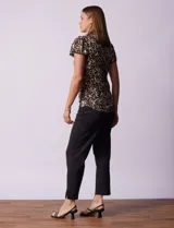 Remera tejida con estampado animal print, de manga corta con detalle de puntilla en las mangas y cuello redondo.