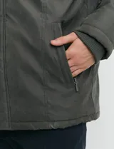 Campera de estilo Harrington en color verde oscuro, con cuello alto, cierre frontal y solapa con botones.
